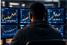 A trader working at several chart monitors